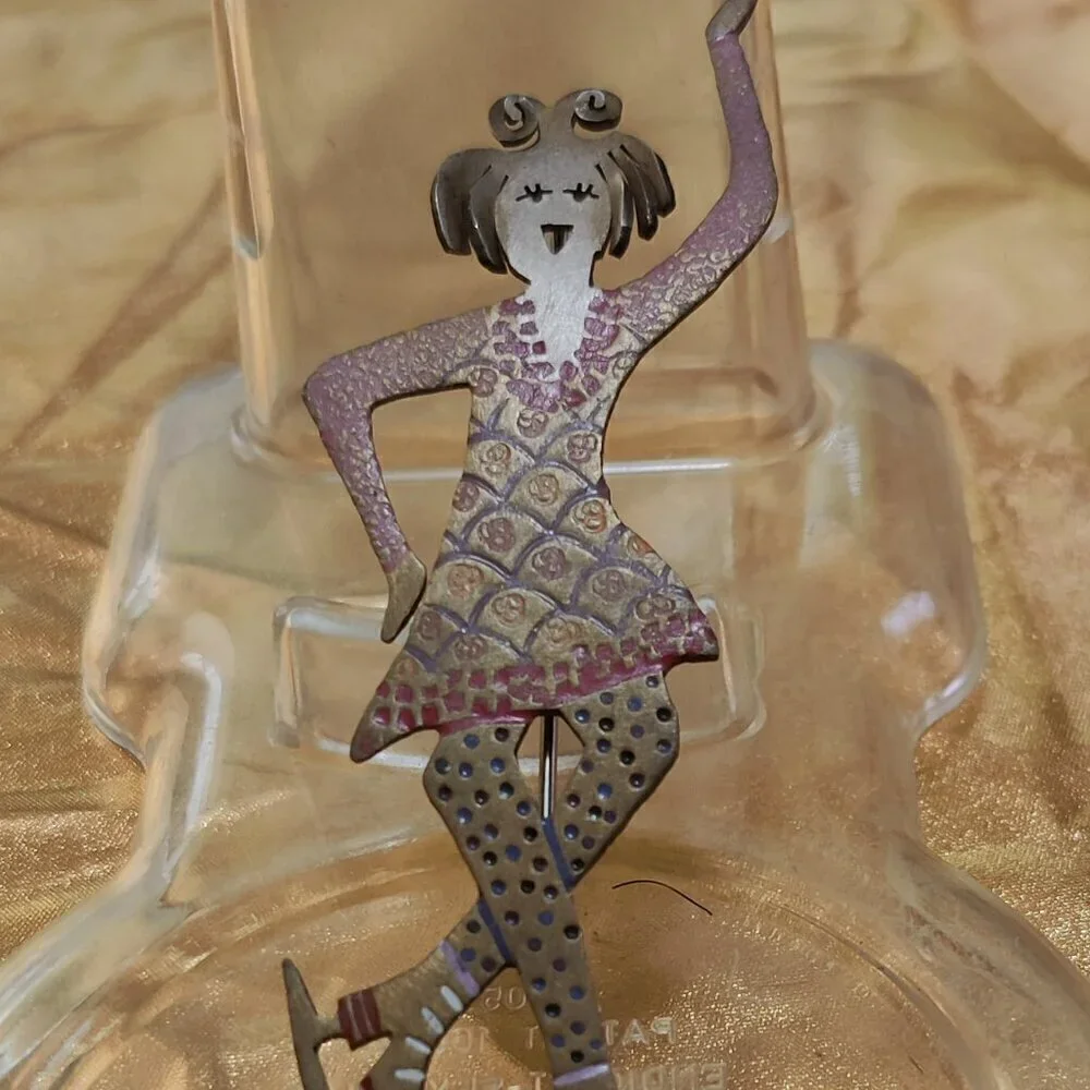Brooch of a whimsical girl Figure Skater. Signed GB.
